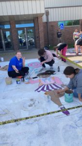 Student painting the sidewalk